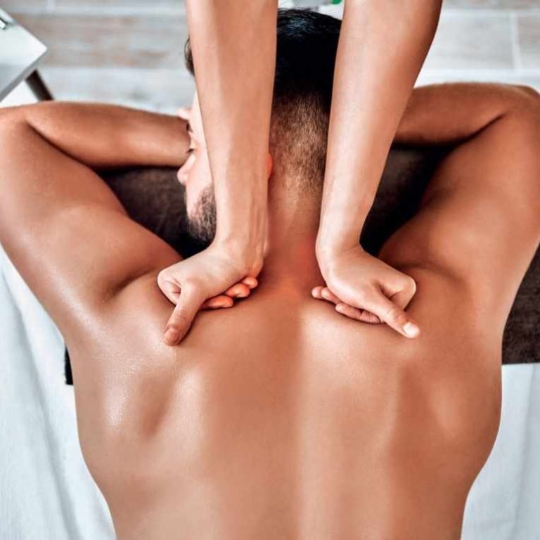 A close-up shot of a person's back being massaged with deep pressure to target muscle knots.