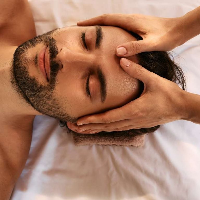 A man getting a soothing head and shoulder massage at a tranquil spa.